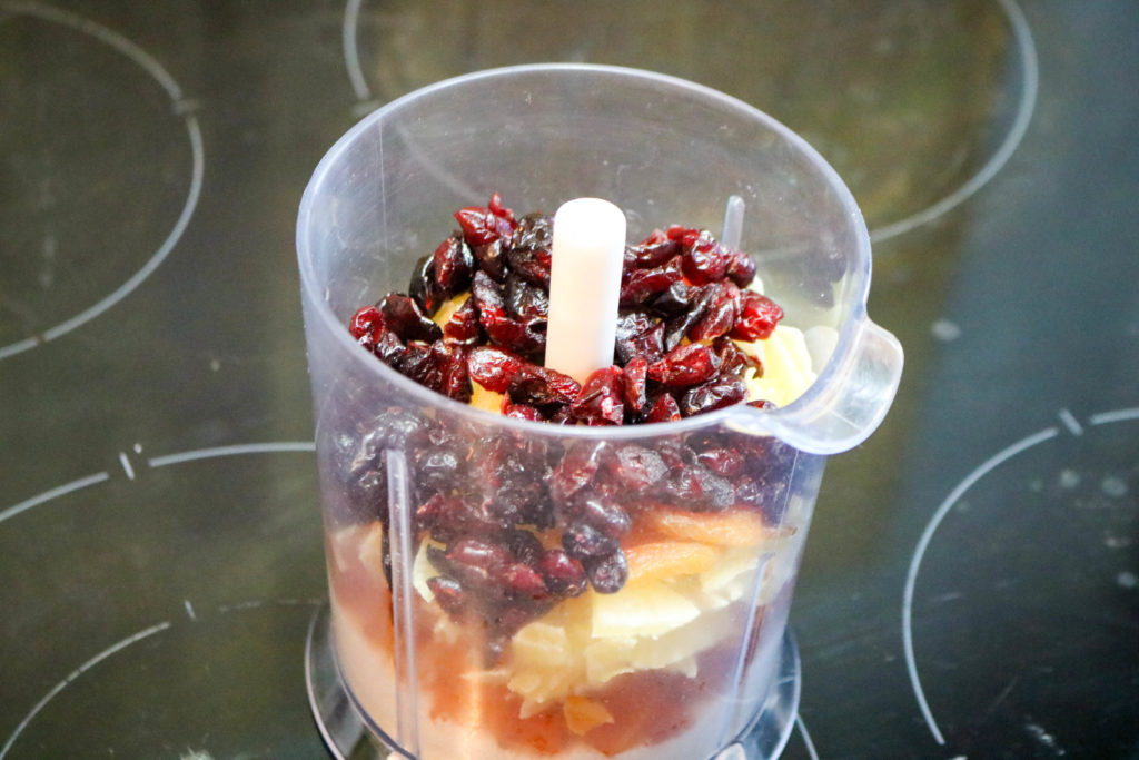 Place coconut, apricots, mango, and cranberries in a food processor