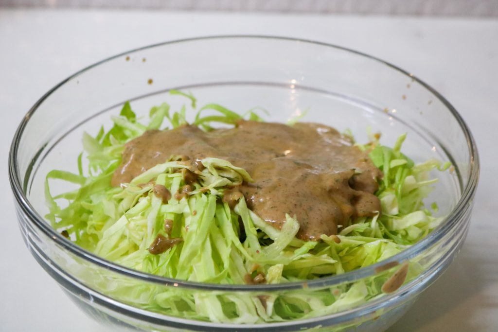 Place coleslaw mix in medium bowl and toss with dressing
